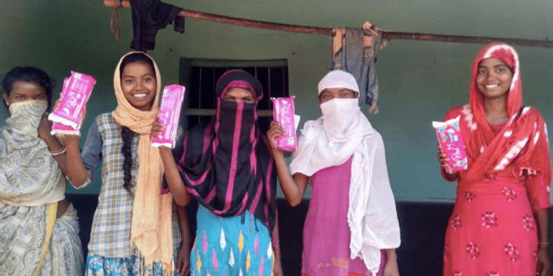 Girls holding sanitary kits after distribution